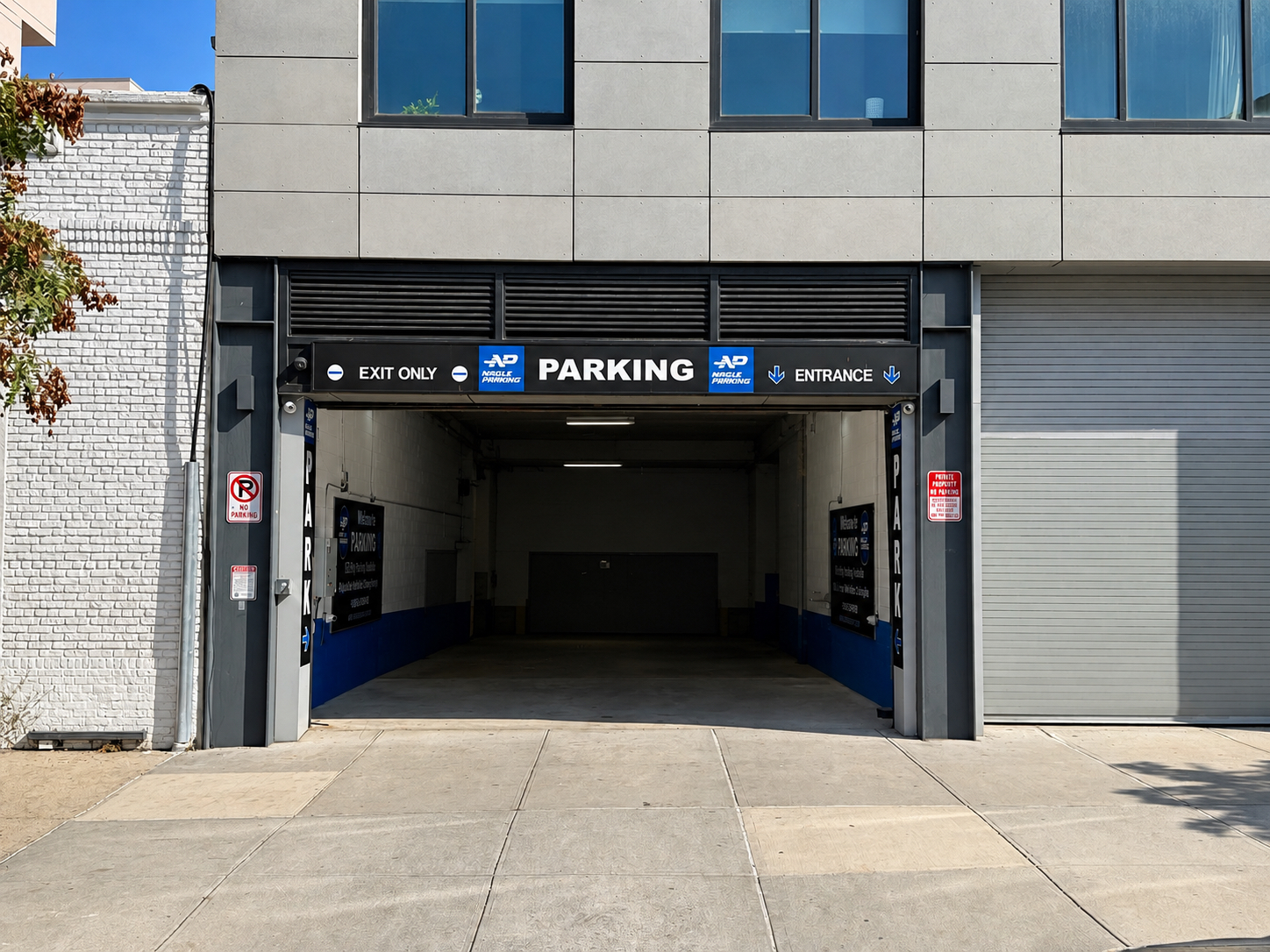 Garage entrance at 125 Metropolitan Avenue with Nagle Parking signs